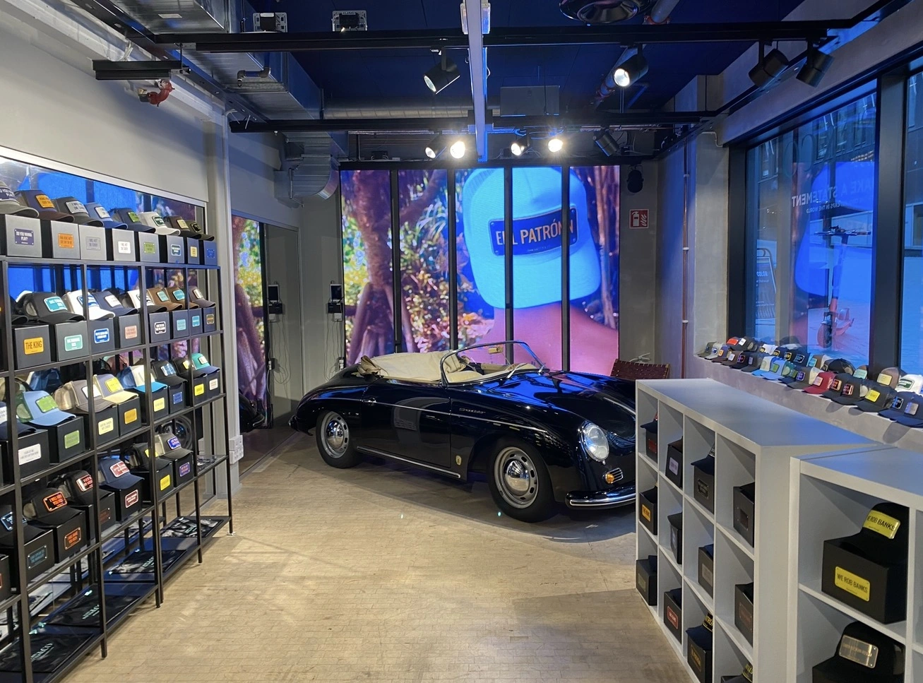 John Hatter and Co store interior with cap displays, campaign screens and a classic convertible